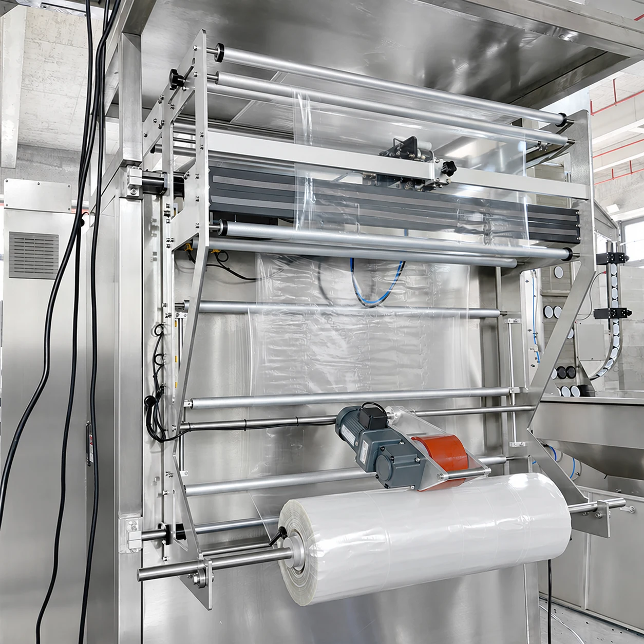 Clear packaging film threaded over tension rollers from a film roll on a vertical bagging machine